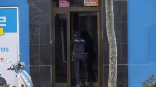 Una policía entra en el edificio de la avenida de Madrid de Zaragoza donde se ha producido el homicidio.