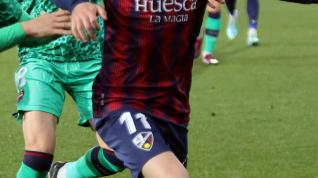Joaquín Muñoz protege el balón ante dos jugadores del Levante.