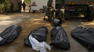 Soldados israelíes junto a los cuerpos de israelíes asesinados por militantes de Hamas en el kibutz Kfar Azza.