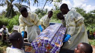 Varios trabajadores sanitarios entierran el cadáver de un hombre que se infectó con ébola tras compartir habitación con un paciente enfermo en Beni (Congo).