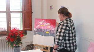 La zaragozana Pilar S., de 31 años, enseña uno de los cuadros que ha pintado en su piso del Actur, donde vive con otras tres compañeras con discapacidad.
