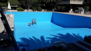 Empleados de Arizón y Gracia trabajando en la rehabilitación y mantenimiento de una piscina.