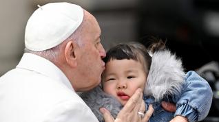 El Papa Francisco besa a un niño al final de su audiencia general semanal en la Plaza de San Pedro.