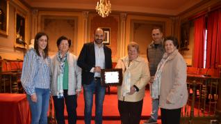 El alcalde de Barbastro, Fernando Torres, entrega el reconocimiento a las viudas durante el acto.