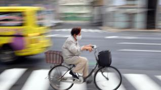 Una mujer mayor va en bici en el barrio de Nihionbashi en Tokyo.