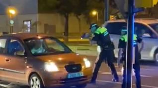 Fotograma de uno de los vídeos que se han difundido por redes sociales en el que se puede ver a unos de los agentes apuntando con un arma al vehículo.