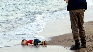 Un gendarme se acerca al niño kurdo sirio Aylan Kurdi, que yace muerto en la playa turca de Bodrum.