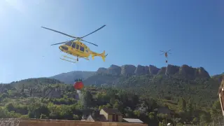 Un helicóptero carga agua antes de dirigirse hacia el incendio