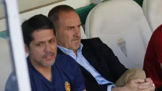 Víctor Fernández, con gesto preocupado, sentado en el banquillo de El Arcángel junto a José Luis Loreto, el segundo técnico del Real Zaragoza.