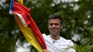 Venezuelan opposition leader Leopoldo Lopez displaying a Venezuelan national flag, greets supporters gathering outside his house in Caracas, after he was released from prison and placed under house arrest for health reasons, on July 8, 2017.Venezuela's Supreme Court confirmed on its Twitter account it had ordered Lopez to be moved to house arrest, calling it a "humanitarian measure" granted on July 7 by the court's president Maikel Moreno. "Leopoldo Lopez is at his home in Caracas with (wife) Lilian and his children," Lopez's Spanish lawyer Javier Cremades said in Madrid. "He is not yet free but under house arrest. He was released at dawn." / AFP PHOTO / Federico PARRA [[[AFP]]] VENEZUELA-CRISIS-OPPOSITION-LOPEZ-HOUSE ARREST