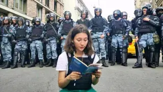 La joven Olga Misik leyendo la constitución frente a la policía.