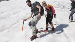 Dos montañeros equipados con piolet y crampones descienden el glaciar.