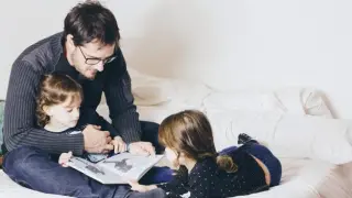 Niños y padre leyendo