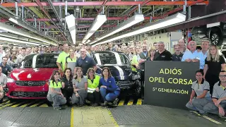 Trabajadores de la planta de Opel España, del grupo PSA, posan con unidades de la quinta y de la sexta generación del Corsa, ayer