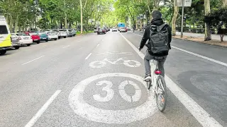 Un ciclista circula por un carril pacificado en el Paseo del Prado de Madrid