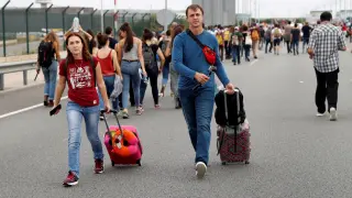 Dos pasajeros llegan caminando al aeropuerto del Prat.