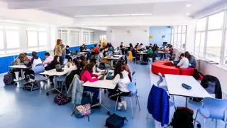 Varios docentes imparten clase a la vez a dos grupos de alumnos en el mismo espacio.