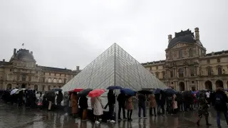 People line up at the Louvre Museum as the staff closed the museum during a staff meeting about the coronavirus outbreak, in Paris