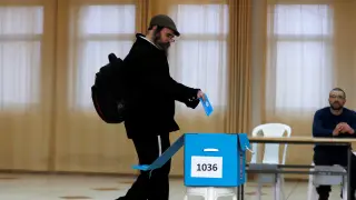 Un hombre introduce su voto en una urna en un colegio electoral del asentamiento judío de Nokdim