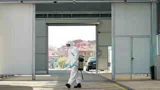 Un bombero desinfecta la entrada de Urgencias del hospital de Burgos.