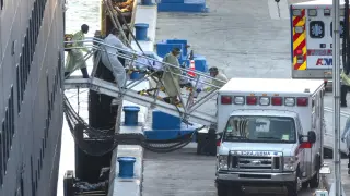 Varois paramédicos desembarcan a un enfermo del crucero 'Zandaam', atracado en Port Everglades, Florida.