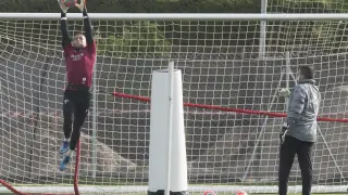 El portero de la SD Huesca Álvaro detiene un balón lanzado por Adrián Mallén, su preparador.