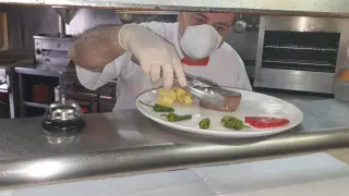 Ángel Lamenca, del hotel Sarao de Escarilla, preparando un plato en su restaurante, que ofrece servicio de terraza y de comida para llevar.