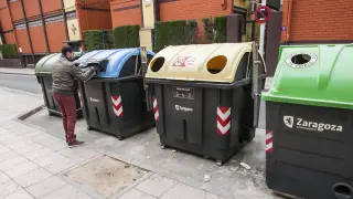 Una persona reciclando en un contenedor de papel en Zaragoza en una imagen de archivo.