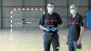 Los bomberos Sergio Blanca y Jesús Araguás, prueban uno de los drones en el parque 1.