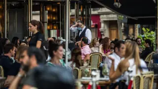 Una terraza de París, llena de clientes.