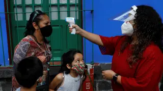 Toma de temperatura a una familia en la visita a la Casa Azul de Frida Kahlo en Ciudad de México.