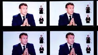 Emmanuel Macron, este miércoles en varias pantallas de televisión.