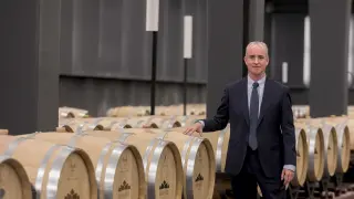 Jorge Costa, junto a unas barricas de vino de la Bodega Sommos de Barbastro, una de las empresas del Grupo Costa.