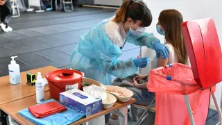Una adolescente recibe la vacuna contra el coronavirus en un instituto polaco.