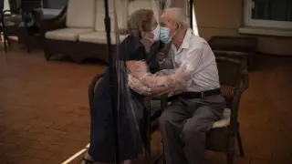 Agustina Cañamero, de 81 años, abraza y besa a su marido, Pascual Pérez, de 84, a través de un plástico en una residencia de Barcelona, el 22 de junio de 2020