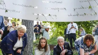 El alcalde de Oslo, Raymond Johansen (i), el príncipe heredero Haakon (4i) y la princesa Mette Marit (2i), entre otras personalidades, en una ofrenda floral en la isla de Utoya, uno de los escenarios de los atentados de hace diez años.