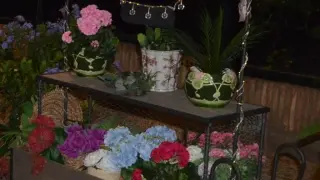 Félix Martínez, atendiendo una mesa junto a un carrito lleno de flores.