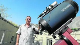 Juan Castiella, junto al telescopio con que escruta el universo.