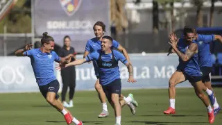Seoane corre perseguido por varios de sus compañeros de la SD Huesca en el entrenamiento del domingo.