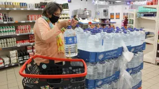 Cari Torres cargando su carro con agua embotellada en un supermercado de Sariñena.
