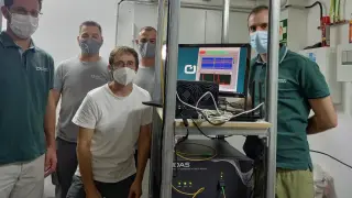 Los ingenieros de Aragón Photonics tras instalar su equipo en La Palma. En la máquina de abajo se lee HDAS, la caja patentada, que se conecta a una pantalla para ver los datos que está recogiendo. La línea vertical que se aprecia en el monitor es un terremoto.
