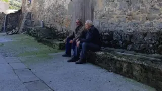 Alejandro y Pablo, sentados delante de su casa
