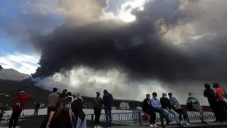 Varias personas observan el volcán desde el mirador.