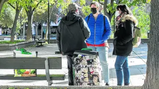 Lucía Capilla y Lucía Conde conversan con un hombre sin hogar en la plaza de José María Forqué