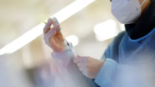 Una enfermera se prepara para inyectar una dosis de vacuna.