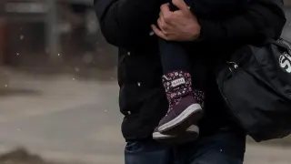 Un hombre con su hija huye de los bombardeos  sobre la ciudad ucraniana de Irvin