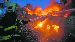 Los bomberos trabajan contra las llamas en el incendio de un gran edificio de Kiev alcanzado por los bombardeos rusos