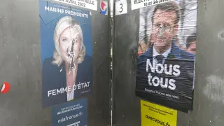 Dos carteles electorales de Emmanuel Macron y Marine Le Pen se "enfrentan" también en las calles de París, este sábado.