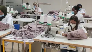 La confección: Trabajadoras de una empresa de inserción de la Fundación San Ezequiel Moreno en Zaragoza confeccionan las bolsas con asa creadas con el material reciclado de los uniformes de empleados de Coca-Cola.