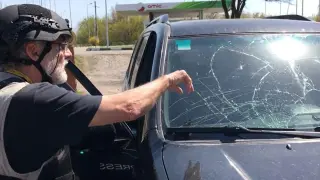 El periodista de RNE Fran Sevilla muestra los destrozos sufridos por el coche.